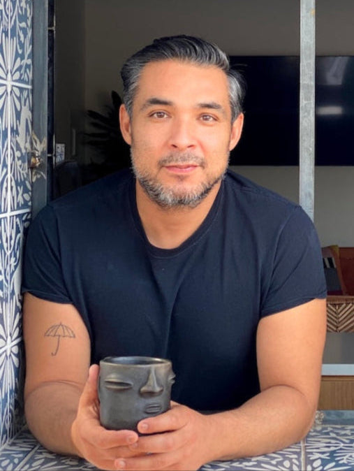 Man holding a mug inside a decorative frame with a room in the background