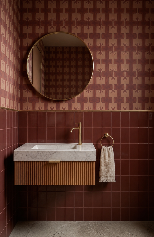 Burgundy Gloss 4x5 Solid Tile from Clay Imports installed vertically on a bathroom wall below patterned wallpaper and gold trim.