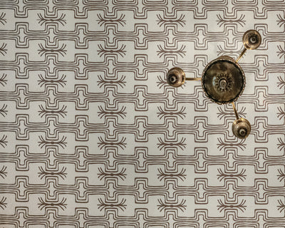 Decorative wall art with geometric pattern and metallic elements on a textured background