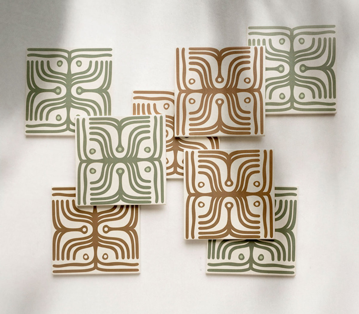 Cream patterned tiles by Clay Imports, featuring abstract green and brown flowing line designs with circles, scattered.