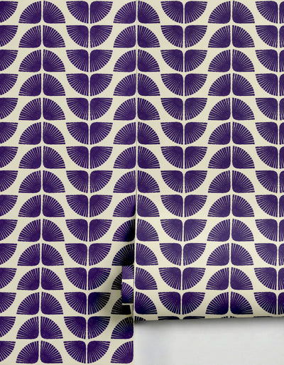 Purple and off-white Petalita Wallpaper by Clay Imports, featuring an art deco-inspired fan pattern, partially rolled.