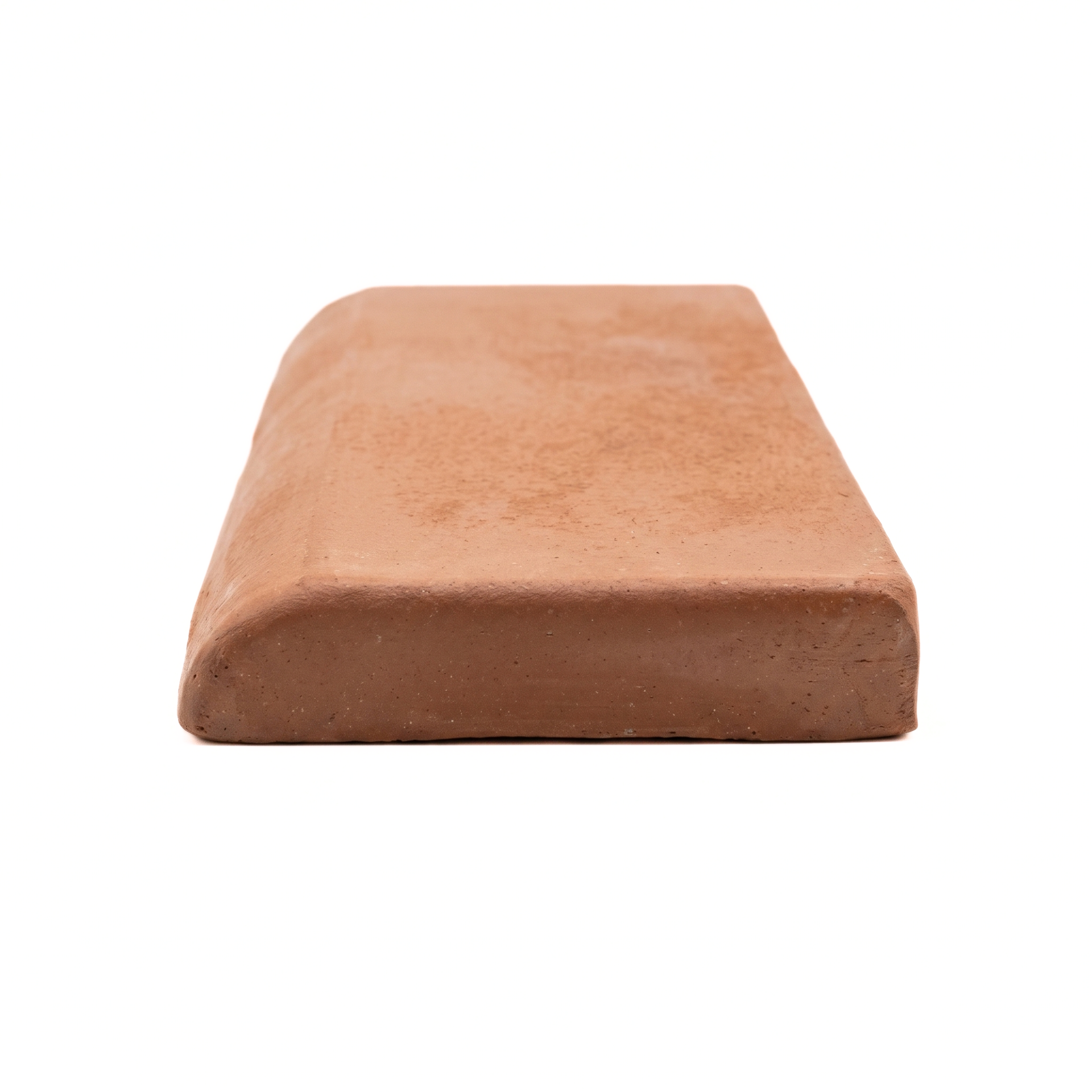 A single terracotta clay tile with a rounded top edge, shown from a low angle on a seamless white background.