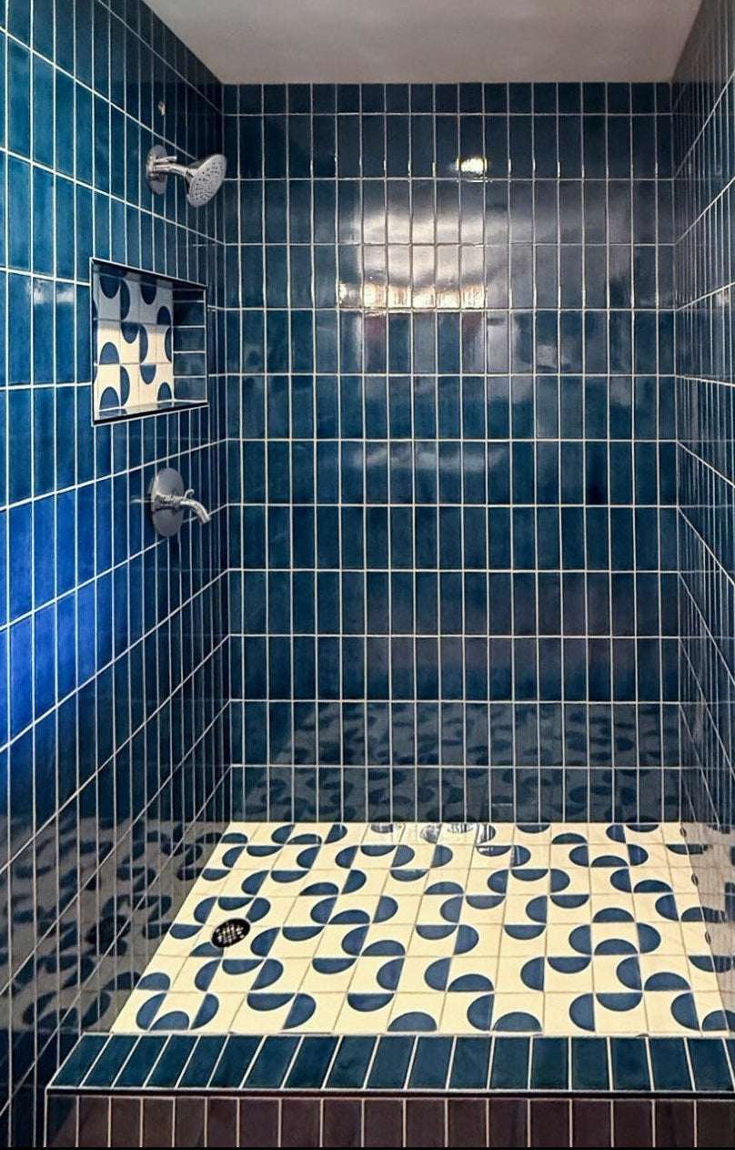 Glossy blue rectangular solid tile by Clay Imports on shower walls and curb with white grout.