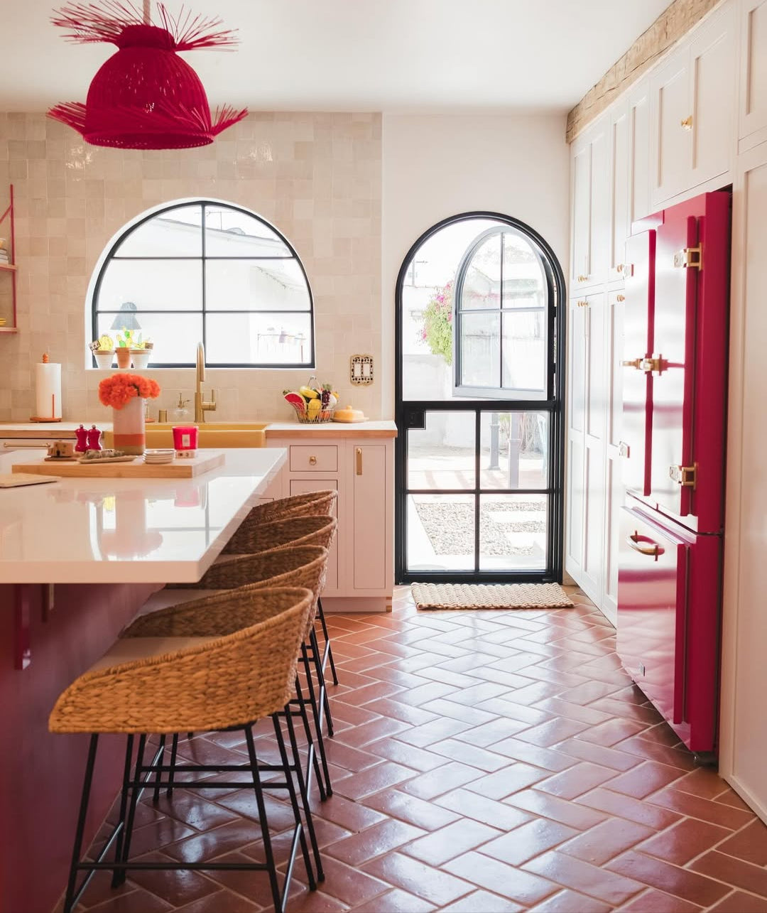 Smooth gloss terracotta tiles by Clay Imports in a reddish-brown herringbone pattern covering a kitchen floor.