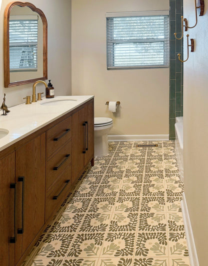 Patterned floor tile by Clay Imports, featuring dark green, sage, and beige leafy motifs on a cream background in a bathroom.