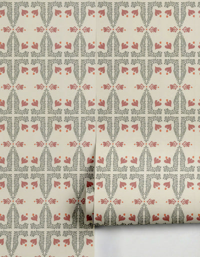 Light beige spring wallpaper by Clay Imports featuring a repeating folk botanical pattern in muted green, dusty rose, and subtle orange dots, partially unrolled.