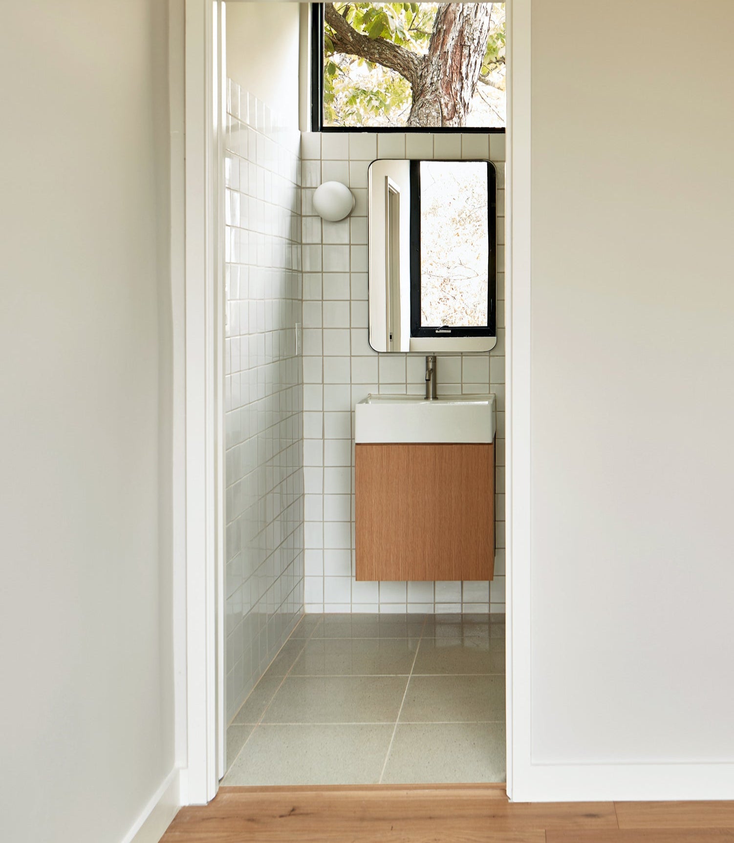 Light solid tile by Clay Imports in a square grid pattern with light grout on a glossy bathroom wall.
