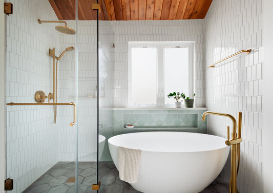 Modern bathroom with freestanding bathtub, glass shower enclosure, and white tiled walls.