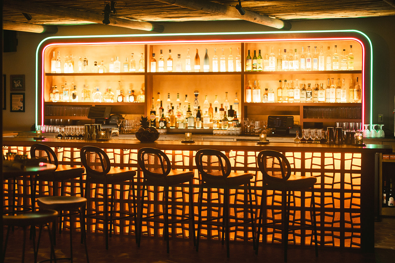 Orange Tigre pattern breeze blocks by Clay Imports Breeze Blocks illuminate a bar counter facade.