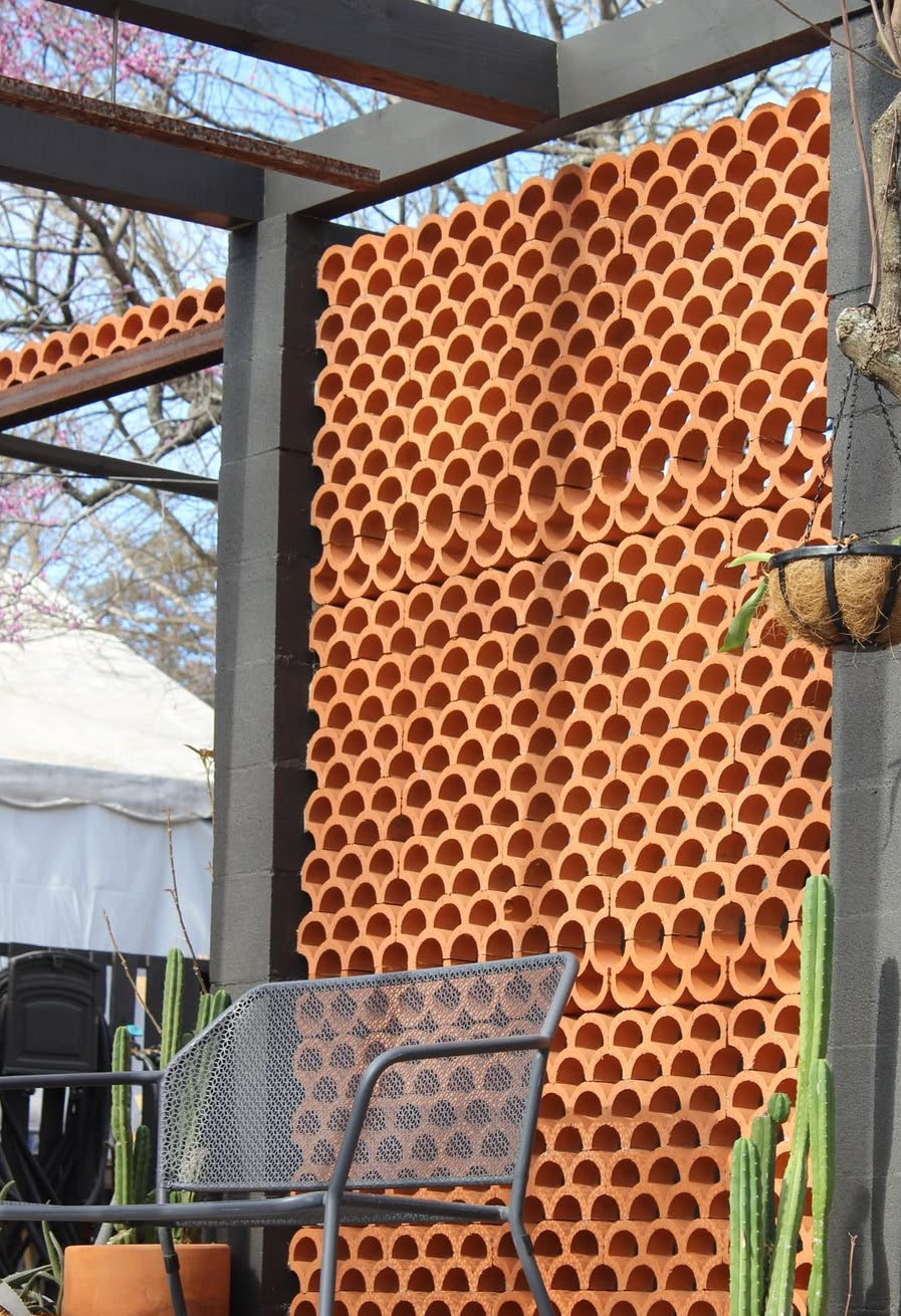 Terracotta breeze blocks by Clay Imports Breeze Blocks, forming an architectural screen with a distinct scalloped pattern.