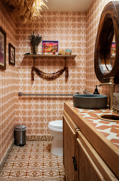Bathroom with patterned wallpaper, wooden vanity, and decorative elements.