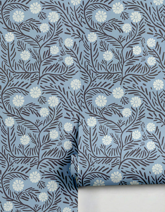 Silvestre Wallpaper by Clay Imports featuring a light blue background with dark botanical vines and white flowers, partially unrolled.