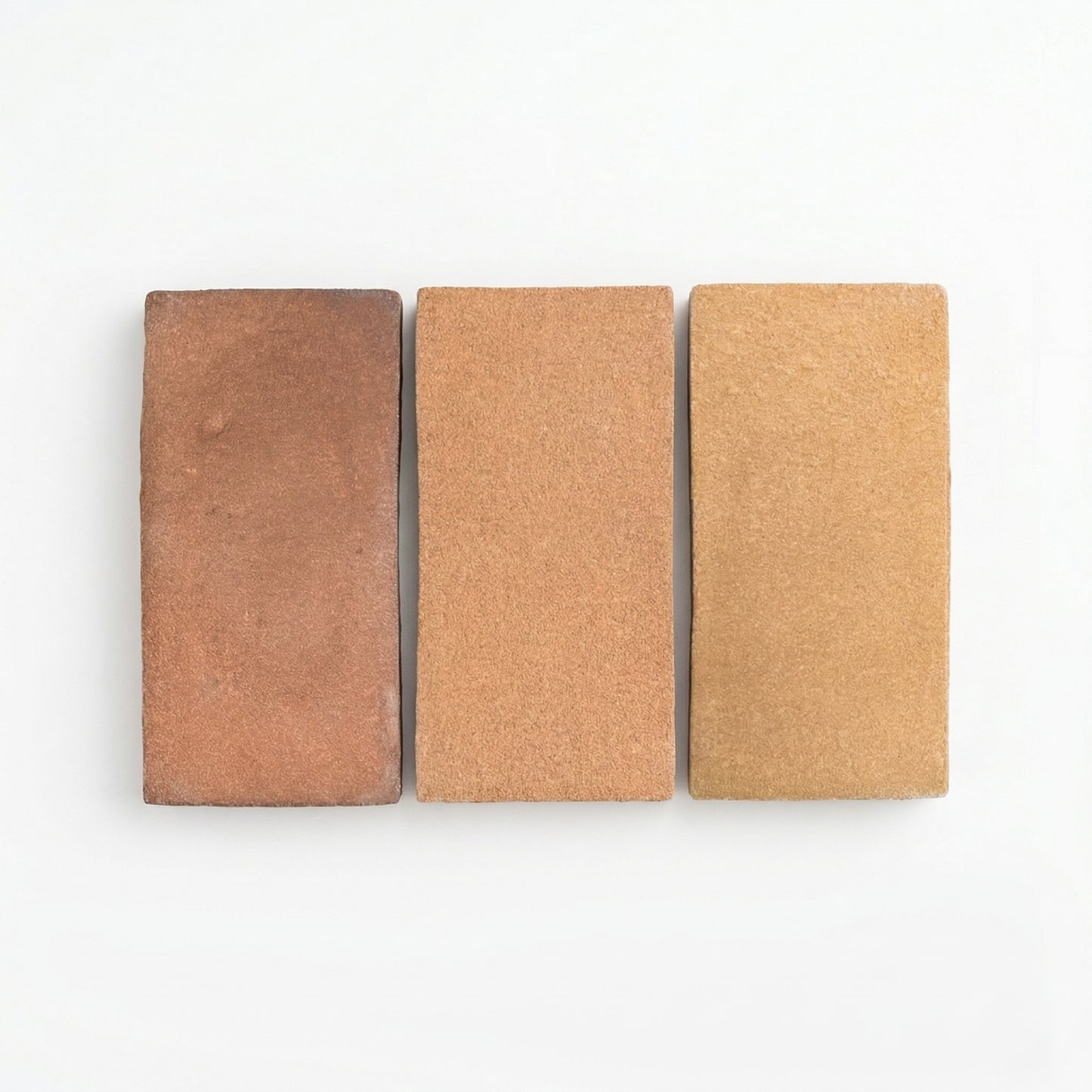 Three rectangular Ember Cotto samples from Clay Imports in varying brown shades with a coarse matte texture, displayed side-by-side.