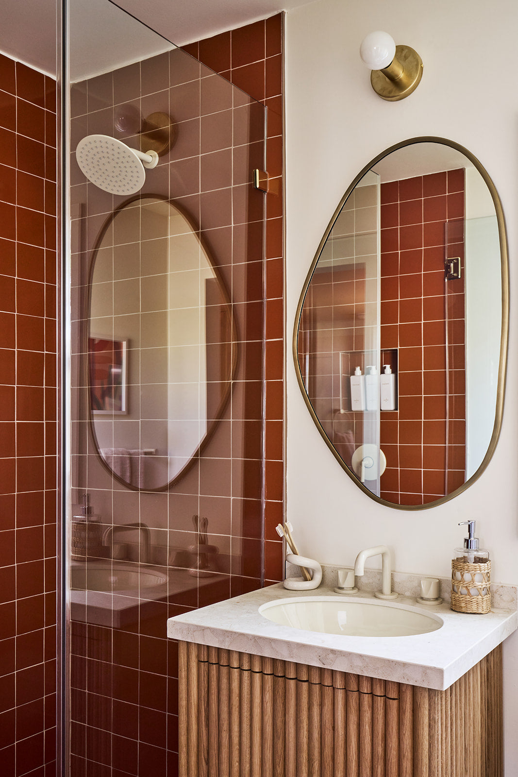 Reddish-brown 4.25x4.25 solid tile by Clay Imports, laid with visible grout lines on a modern bathroom shower wall.
