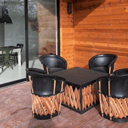 Black square coffee table by Clay Imports with a diagonal wooden slatted base on a deck.
