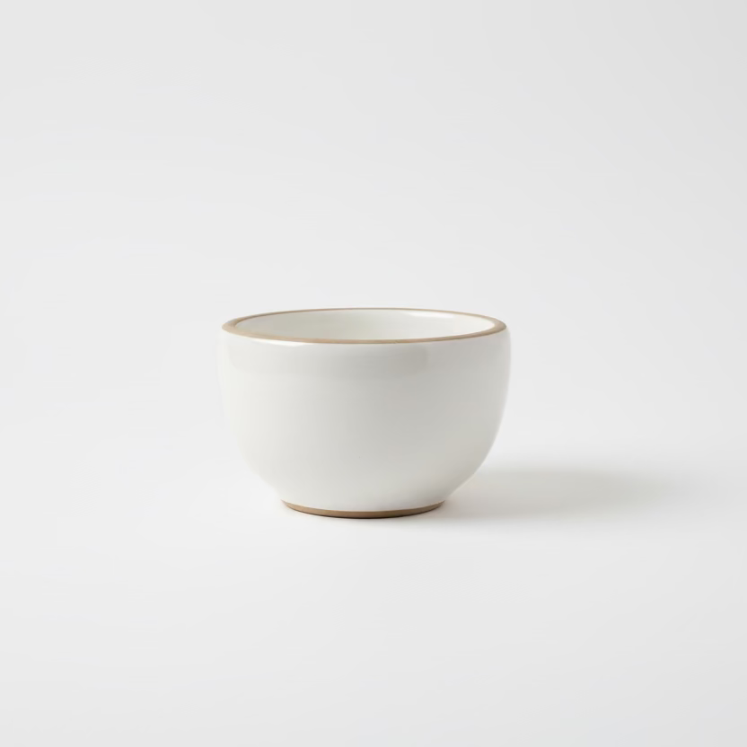 White gloss ceramic tea cup by Clay Imports with an unglazed rim and base.