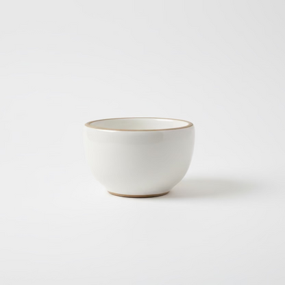 White gloss ceramic tea cup by Clay Imports with an unglazed rim and base.