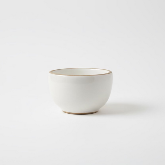 White gloss ceramic tea cup by Clay Imports with an unglazed rim and base.