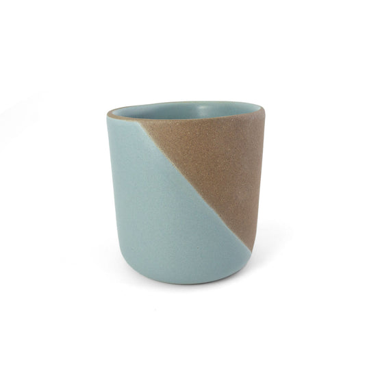 A two-toned ceramic copita by Clay Imports with a diagonal color block design in light blue and brown.