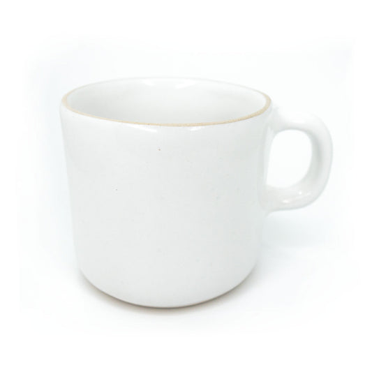 White ceramic mug by Clay Imports with a light brown rim and a simple handle, viewed from the side.