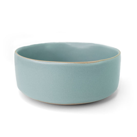 Light blue ceramic bowl by Clay Imports with a contrasting unglazed rim, shown from a side view.