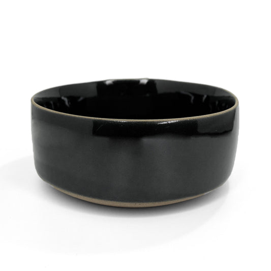 Black clay Everything Bowl by Clay Imports with a visible unglazed natural clay base, viewed from the side.