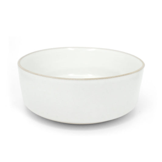 White round bowl by Clay Imports with a raw, unglazed rim, shown from the side.